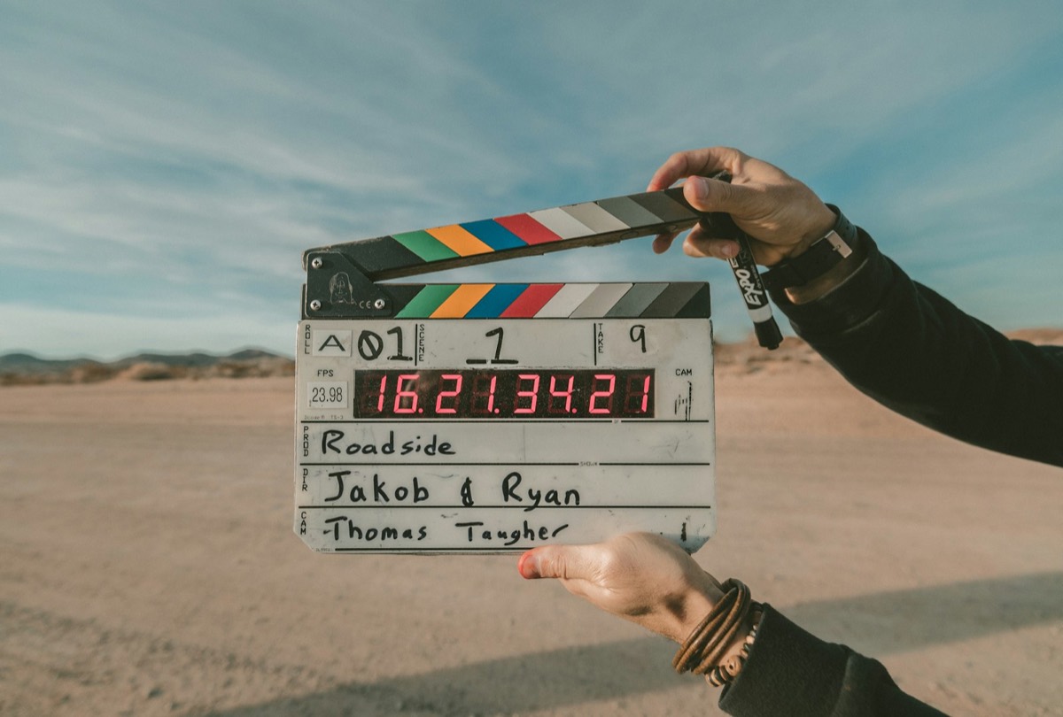 Clap de tournage tenu à bout de bras dans le désert